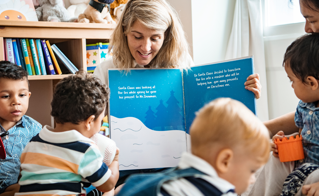 BSCP home page pointer to Carers and The Community: image of a group of children and a couple of adults in reading session