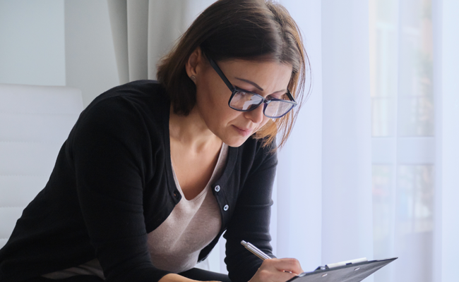 BSCP home page pointer to Professionals: image of a professional woman writing on a clipboard